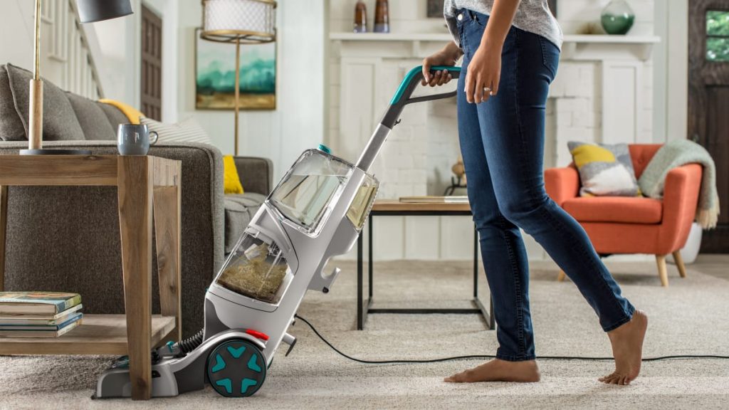 a girl cleaning rug with a modern carpet cleaning machine